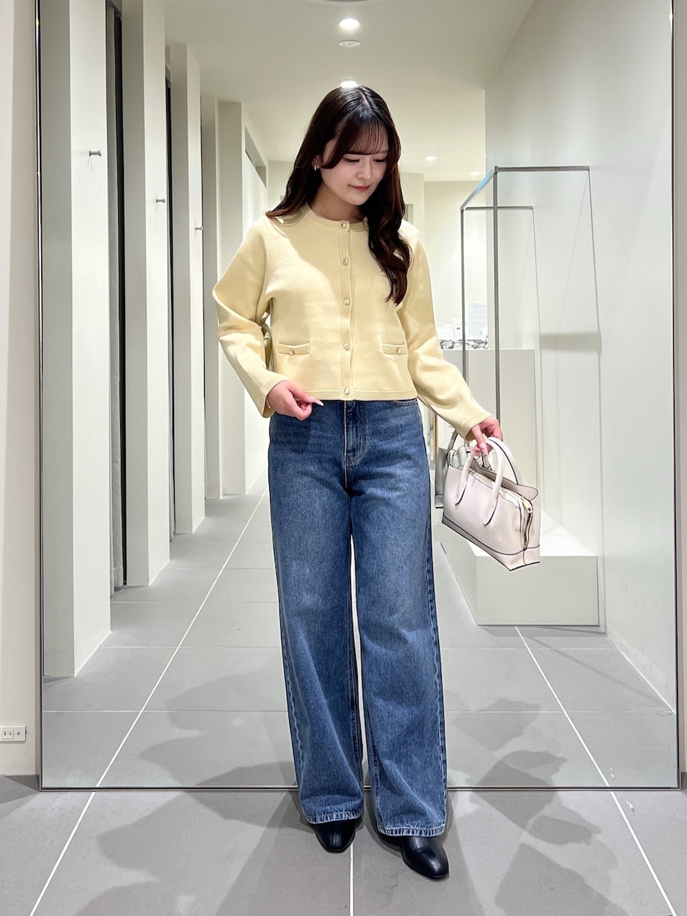 イエロー系のカーディガン/ボレロ、ブルー系のデニムパンツ、ホワイト系のトートバッグを着用したレディースの夏コーディネートの5枚目の写真