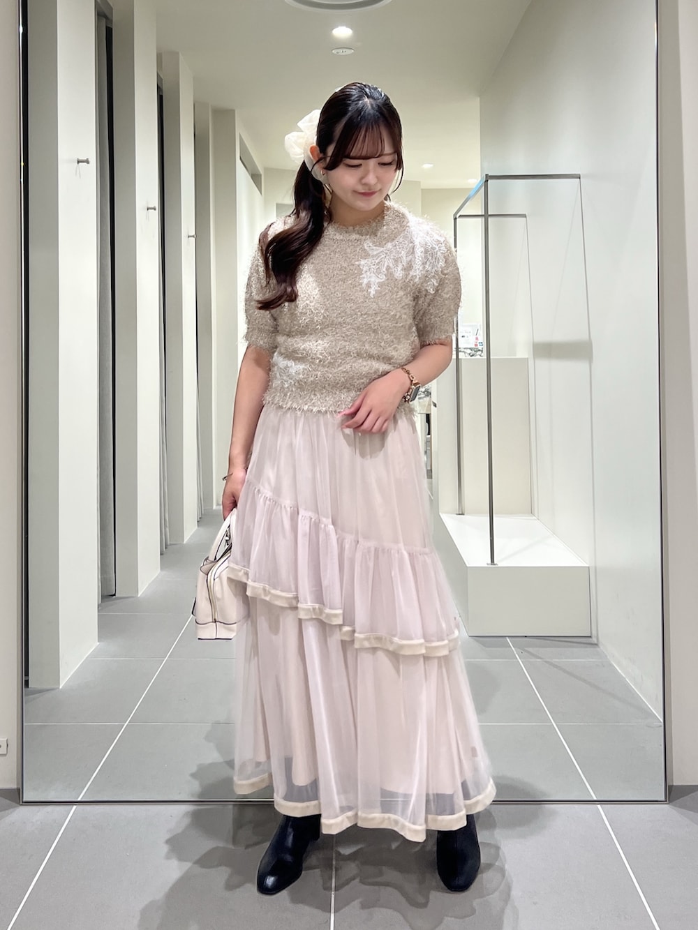 ベージュ系のニット/セーター、ベージュ系のスカート、ホワイト系のトートバッグを着用したレディースの夏コーディネートの4枚目の写真