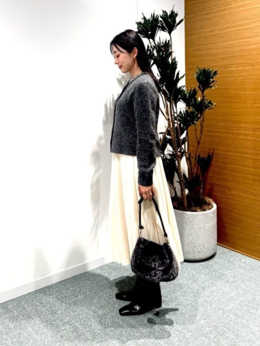 ホワイト系のスカート、グレー系のカーディガン/ボレロを着用したレディースの秋コーディネートの3枚目の写真