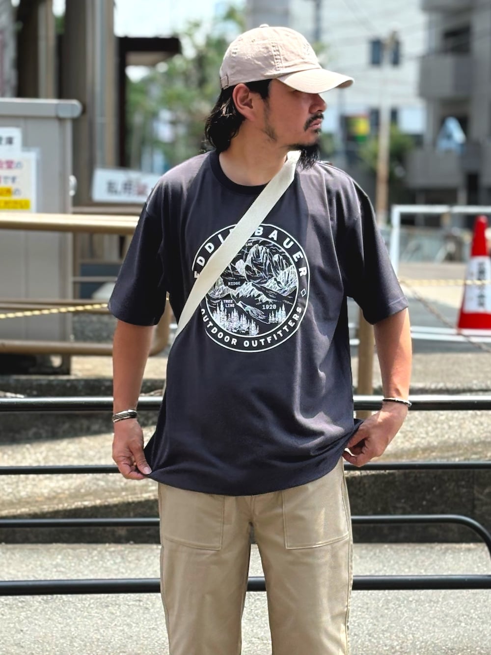 ホワイト系のトートバッグ、グレー系のTシャツ/カットソー、ベージュ系のその他パンツを着用したメンズの夏コーディネートの2枚目の写真