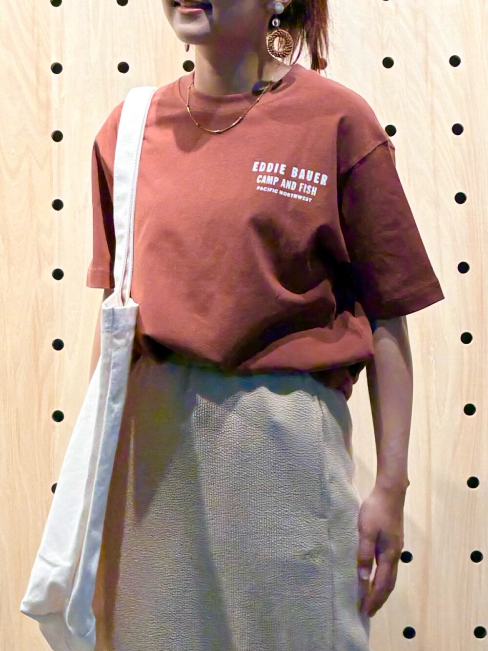 ブラウン系のTシャツ/カットソー、ベージュ系のスカート、ホワイト系のトートバッグを着用したレディースの夏コーディネートの3枚目の写真