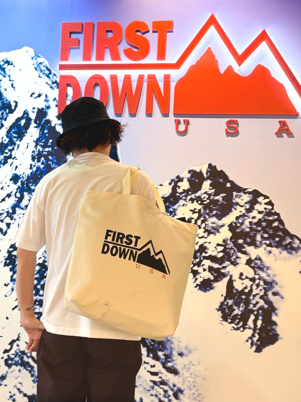ホワイト系のTシャツ/カットソー、ブルー系のその他パンツ、ホワイト系のトートバッグを着用したメンズの夏コーディネートの2枚目の写真