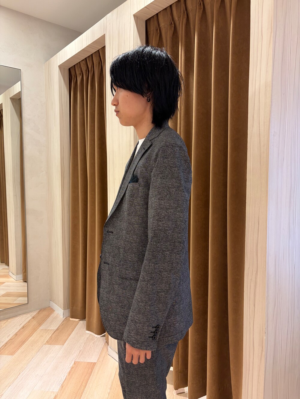 ブラック系のテーラードジャケット、ブラック系のスラックス、ホワイト系のTシャツ/カットソーを着用したメンズの夏コーディネートの5枚目の写真