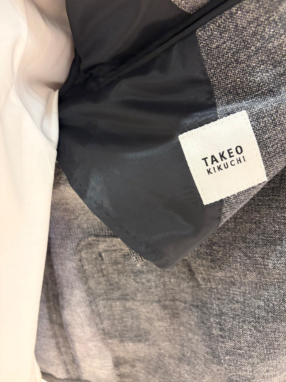 ブラック系のテーラードジャケット、ブラック系のスラックス、ホワイト系のTシャツ/カットソーを着用したメンズの夏コーディネートの10枚目の写真