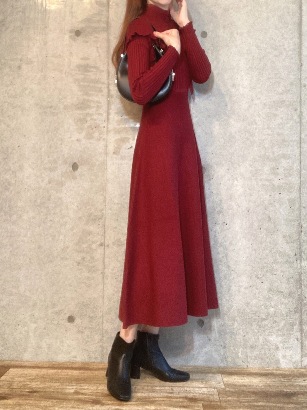 ブラウン系のワンピース、ブラック系のハンドバッグ、ブラック系のブーツを着用したレディースの秋コーディネートの3枚目の写真