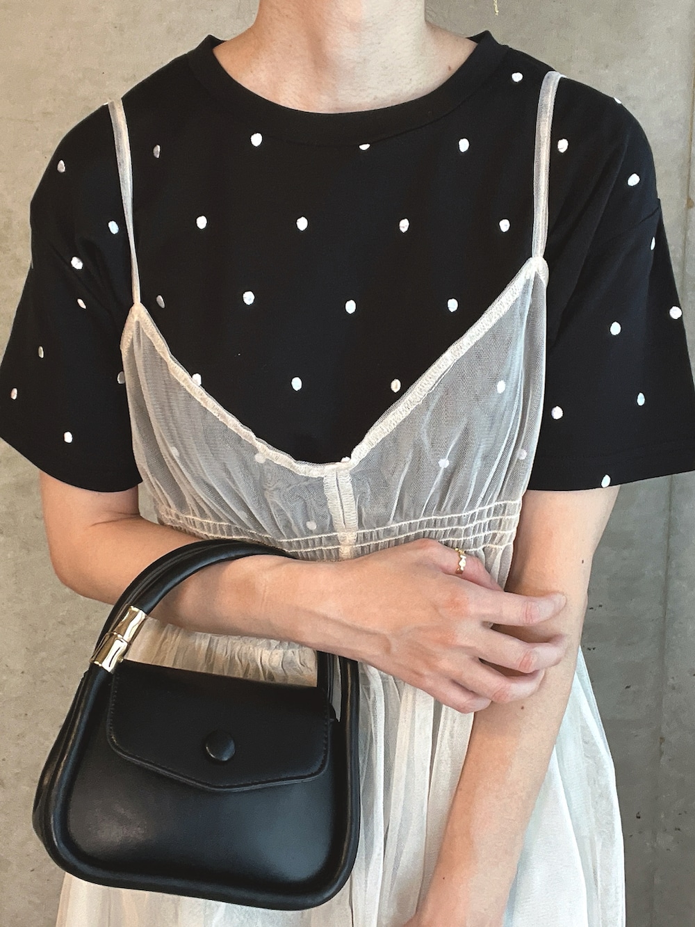 ブラック系のTシャツ/カットソー、ブラック系のショルダーバッグ、ブルー系のデニムパンツを着用したレディースの秋コーディネートの2枚目の写真