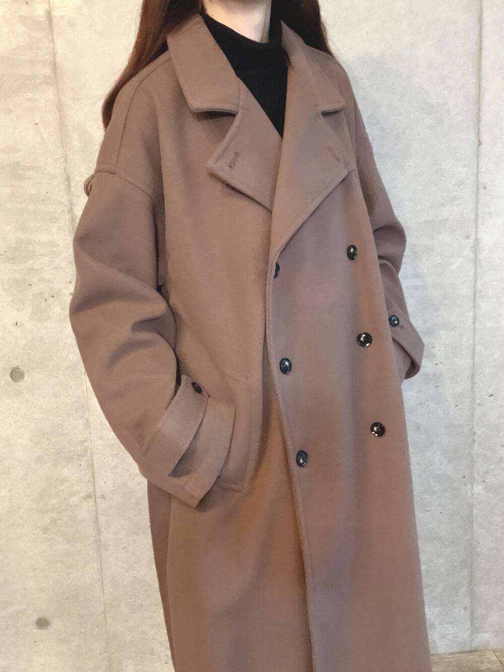 ブラック系のハンドバッグ、ホワイト系のスラックス、ブラウン系のブーツを着用したレディースの冬コーディネートの4枚目の写真