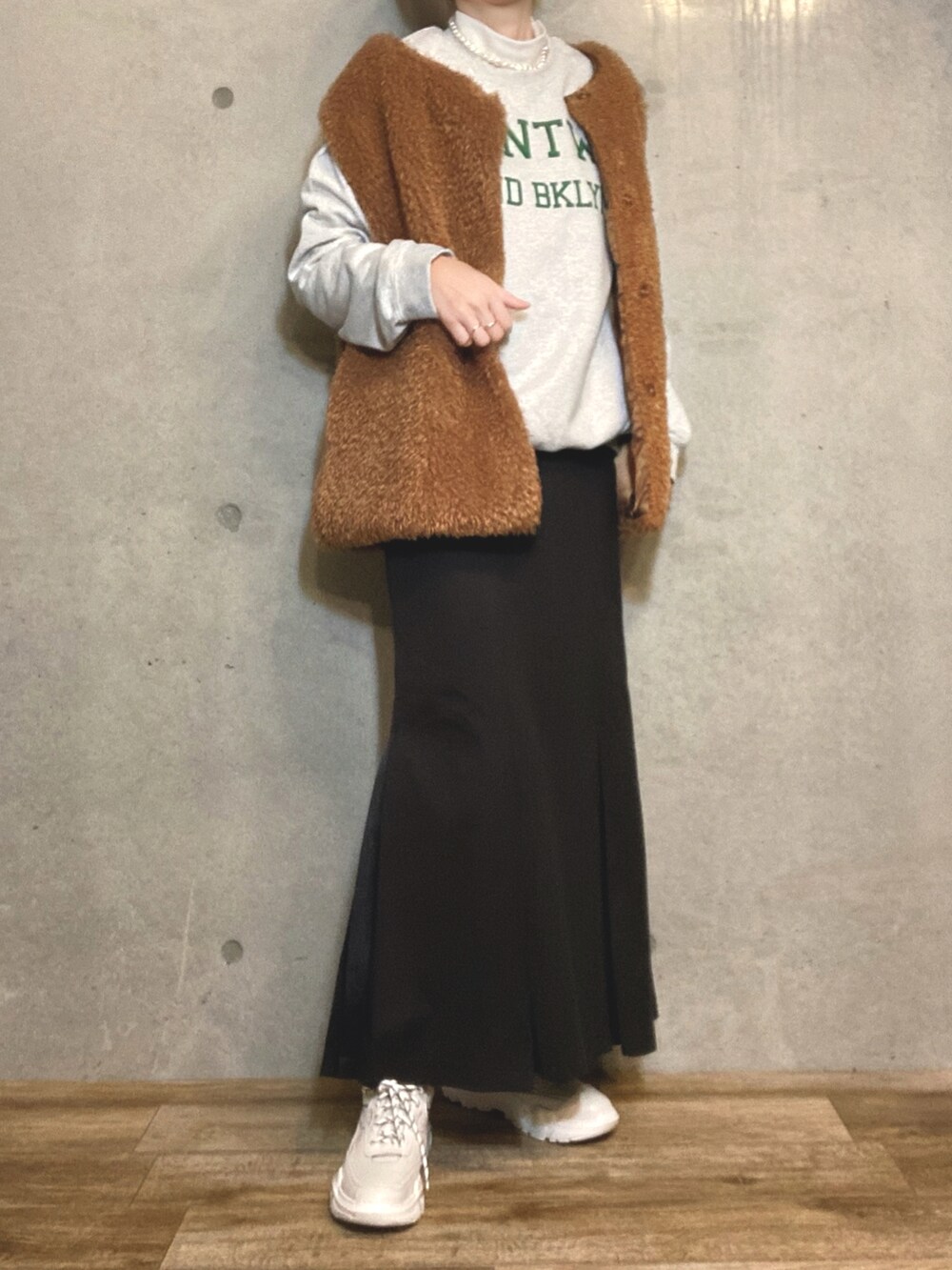 ブラック系のトートバッグ、ブラック系のスカート、ホワイト系のスニーカーを着用したレディースの冬コーディネートの3枚目の写真