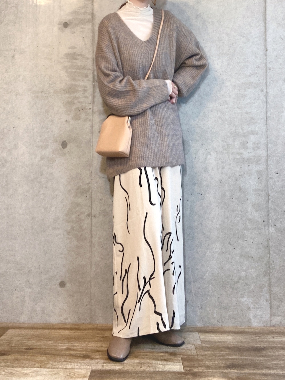 ベージュ系のニット/セーター、ベージュ系のTシャツ/カットソー、ホワイト系のワンピースを着用したレディースの秋コーディネートの3枚目の写真