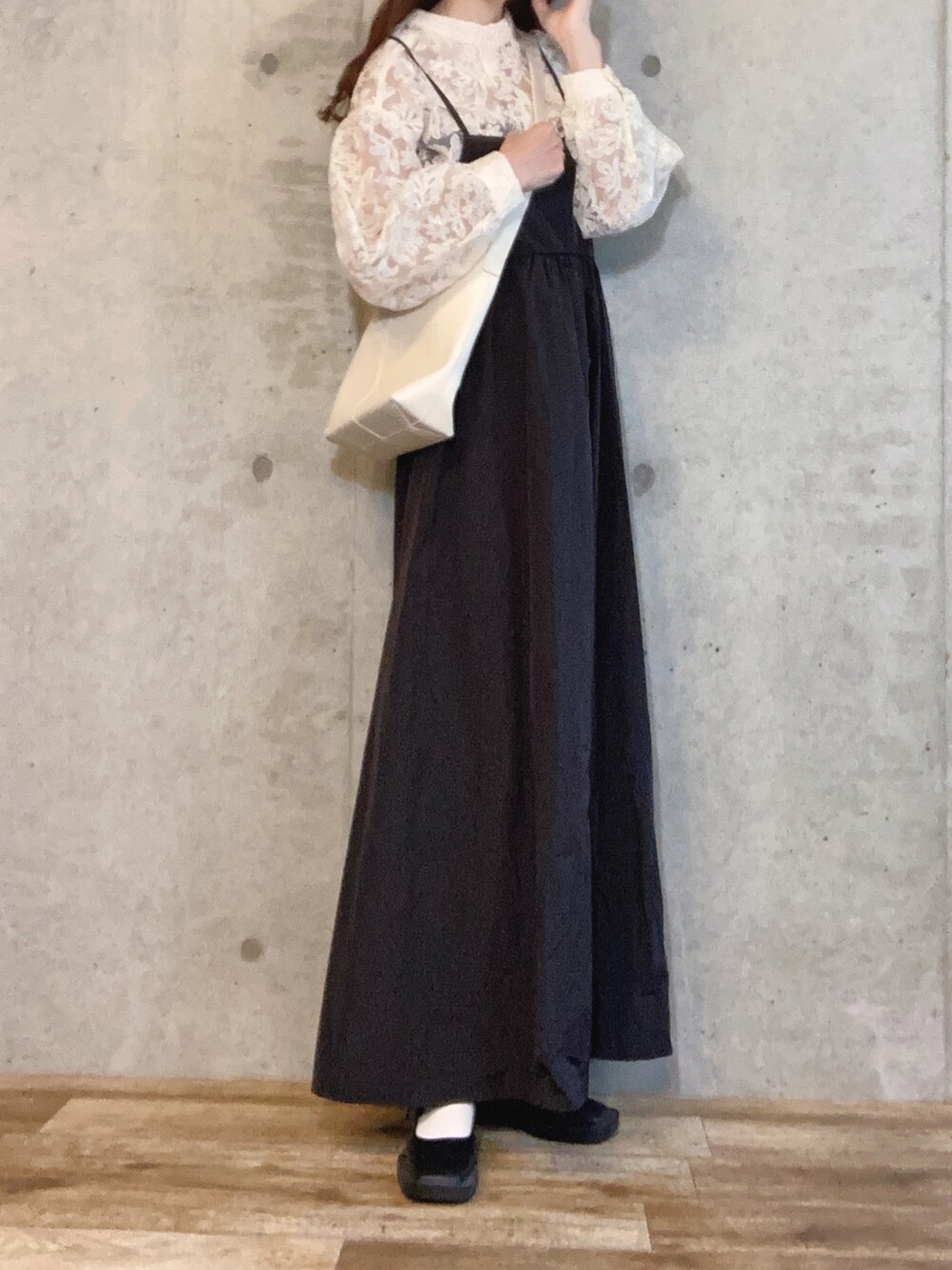 ブラック系のワンピース、ホワイト系のショルダーバッグ、ブラック系のパンプスを着用したレディースの春コーディネートの2枚目の写真