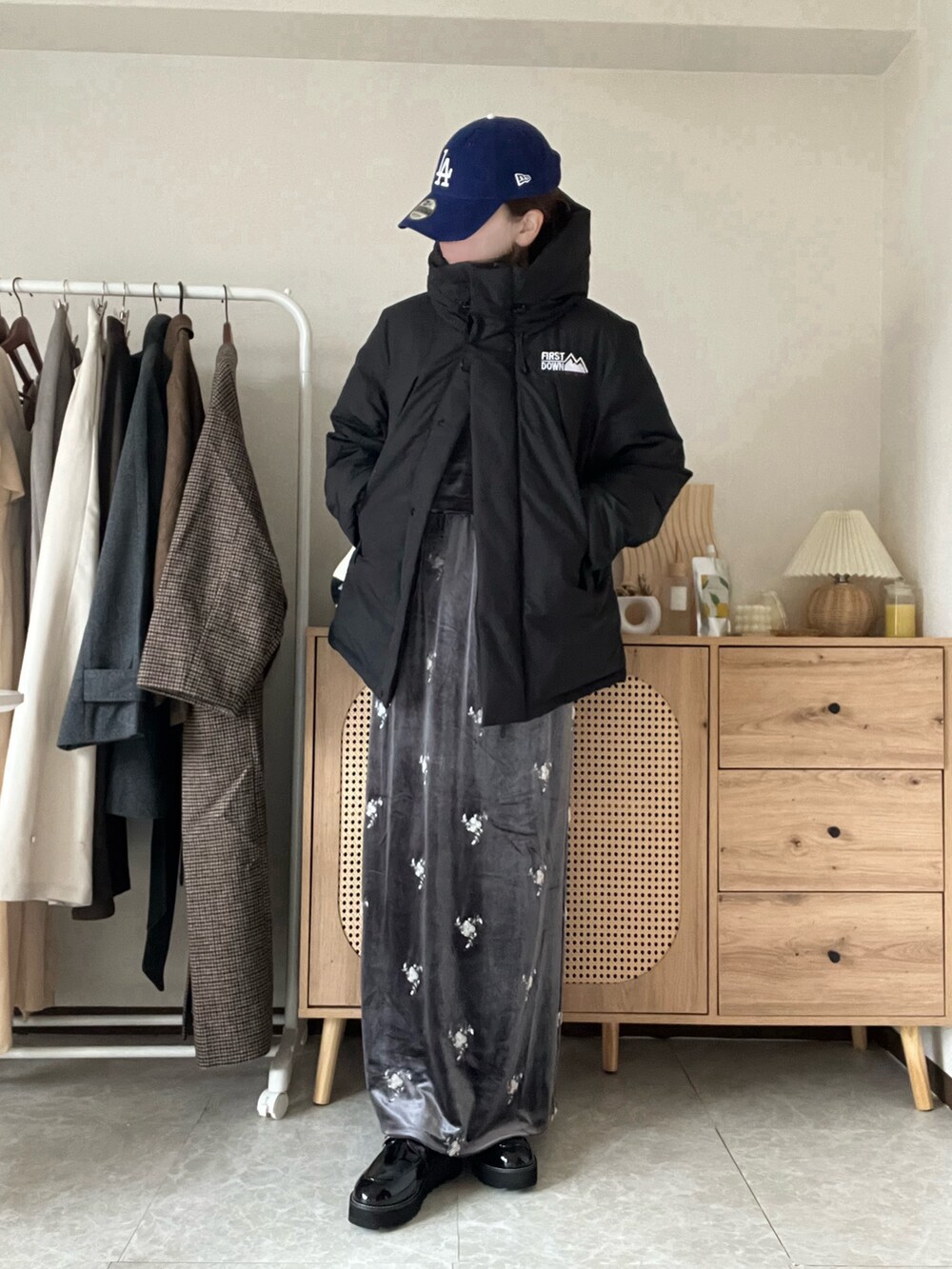 ブラック系のダウンジャケット/コート、グレー系のスカート、ブルー系のシャツ/ブラウスを着用したレディースの冬コーディネートの5枚目の写真