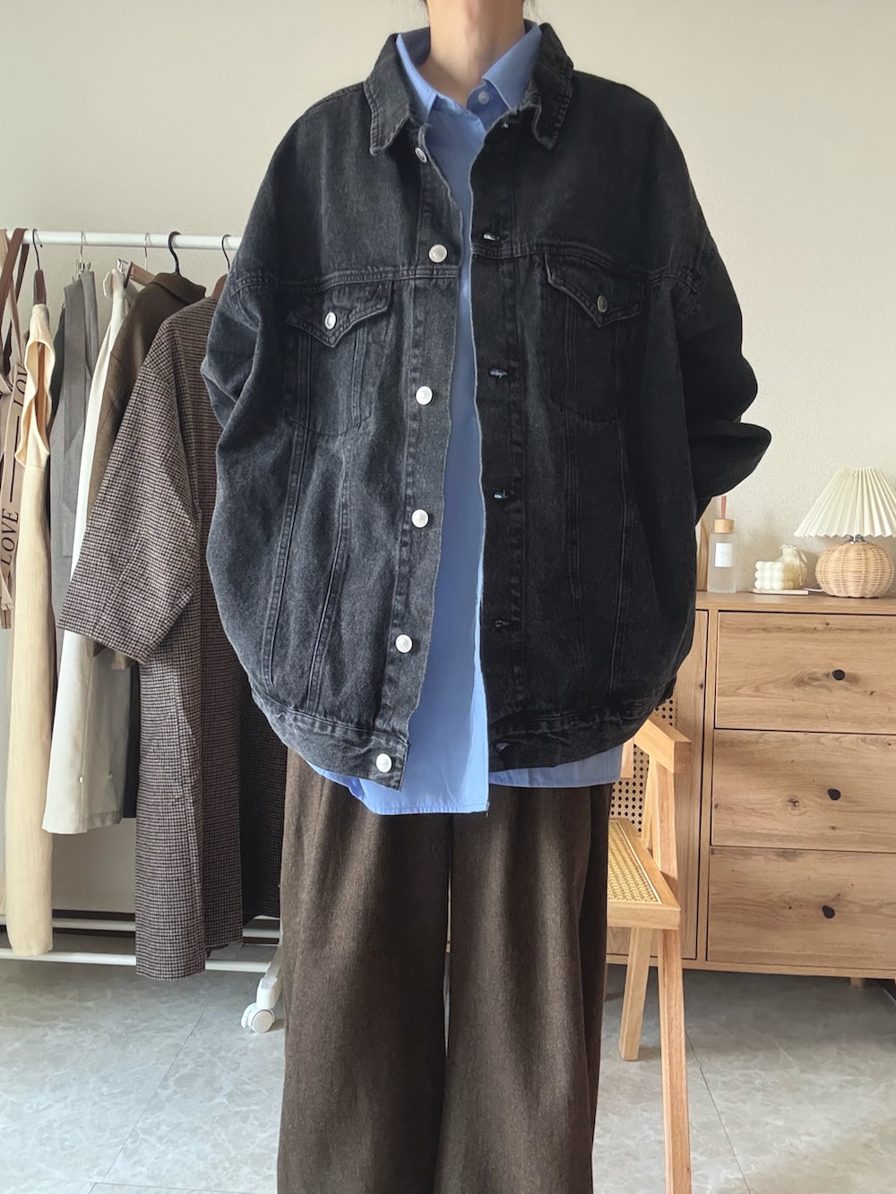 ブラック系のデニムジャケット、ブラック系のブーツ、ブラック系のトートバッグを着用したレディースの冬コーディネートの4枚目の写真