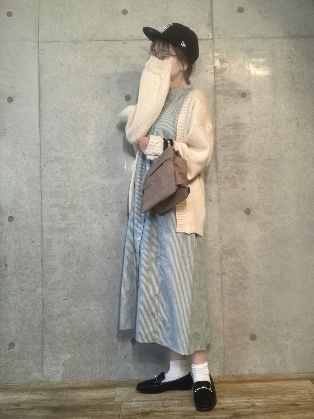 ホワイト系のカーディガン/ボレロ、グリーン系のワンピース、ブラウン系のショルダーバッグを着用したレディースの春コーディネートの2枚目の写真