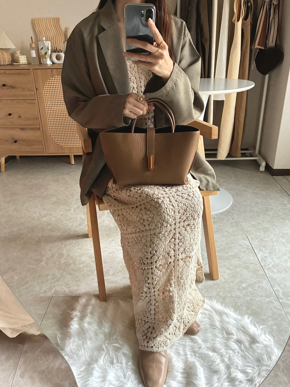 ベージュ系のテーラードジャケット、ホワイト系のワンピース、ブラウン系のハンドバッグを着用したレディースの春コーディネートの3枚目の写真