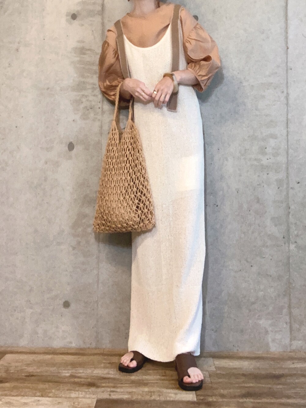 オレンジ系のシャツ/ブラウス、ホワイト系のワンピース、ブラウン系のかごバッグを着用したレディースの夏コーディネートの2枚目の写真