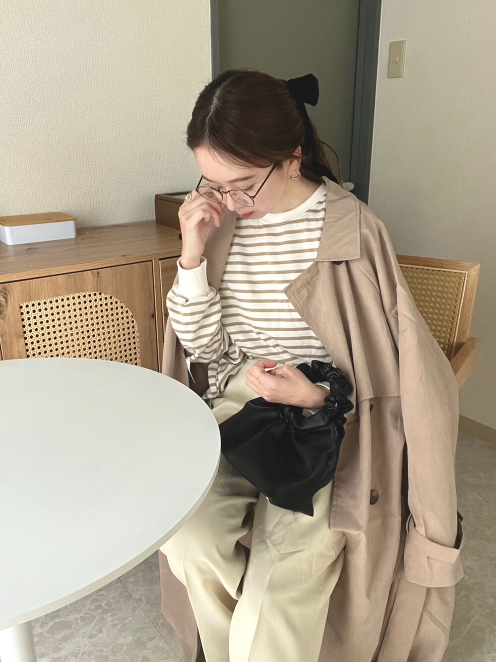 ベージュ系のトレンチコート、ベージュ系のTシャツ/カットソー、ホワイト系のその他パンツを着用したレディースの春コーディネートの4枚目の写真