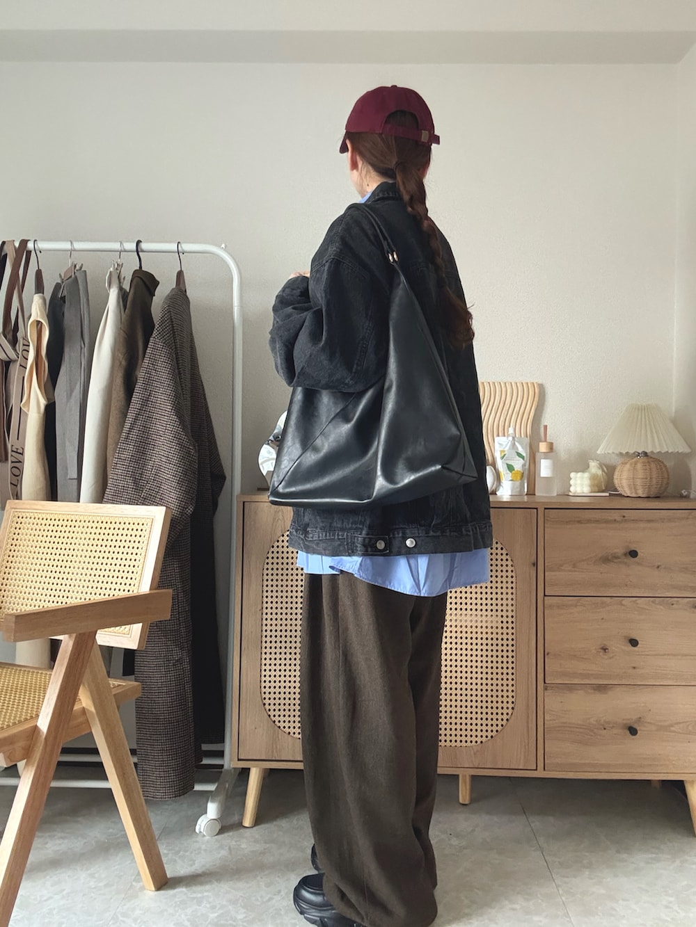 ブラック系のデニムジャケット、ブラック系のブーツ、ブラック系のトートバッグを着用したレディースの冬コーディネートの2枚目の写真