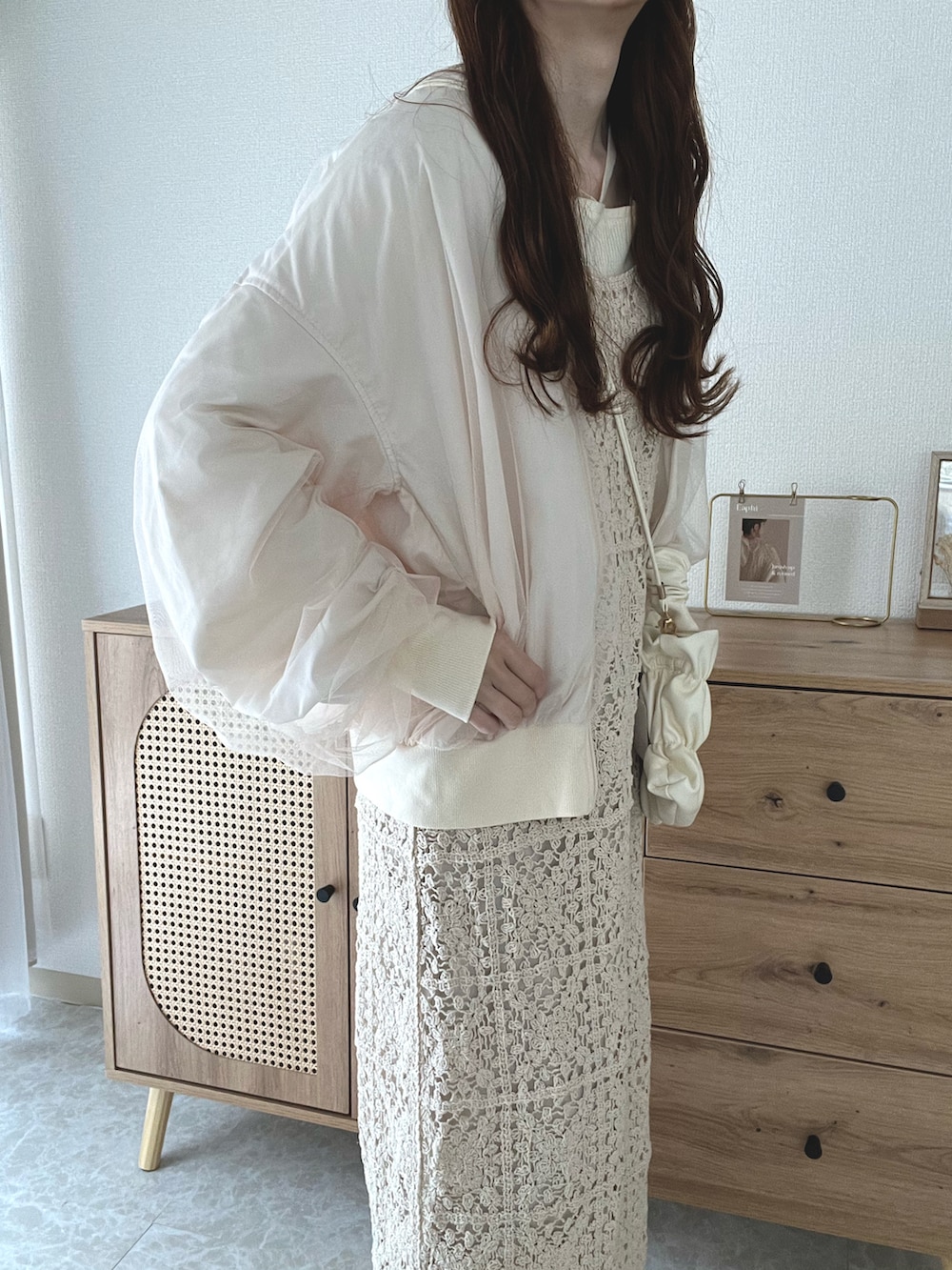 ホワイト系のブルゾン、ホワイト系のニット/セーター、ホワイト系のワンピースを着用したレディースの春コーディネートの3枚目の写真