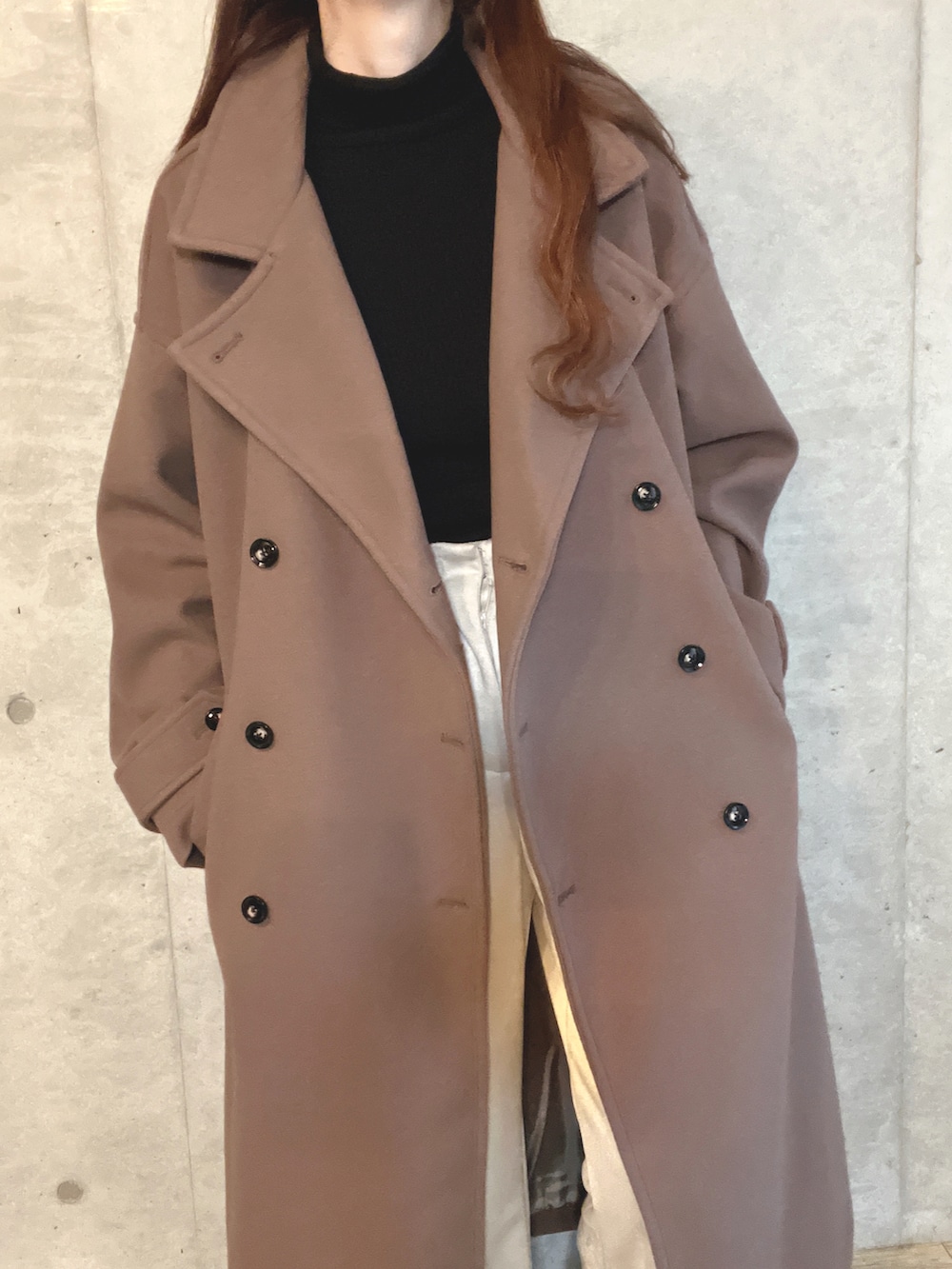 ブラック系のハンドバッグ、ホワイト系のスラックス、ブラウン系のブーツを着用したレディースの冬コーディネートの5枚目の写真