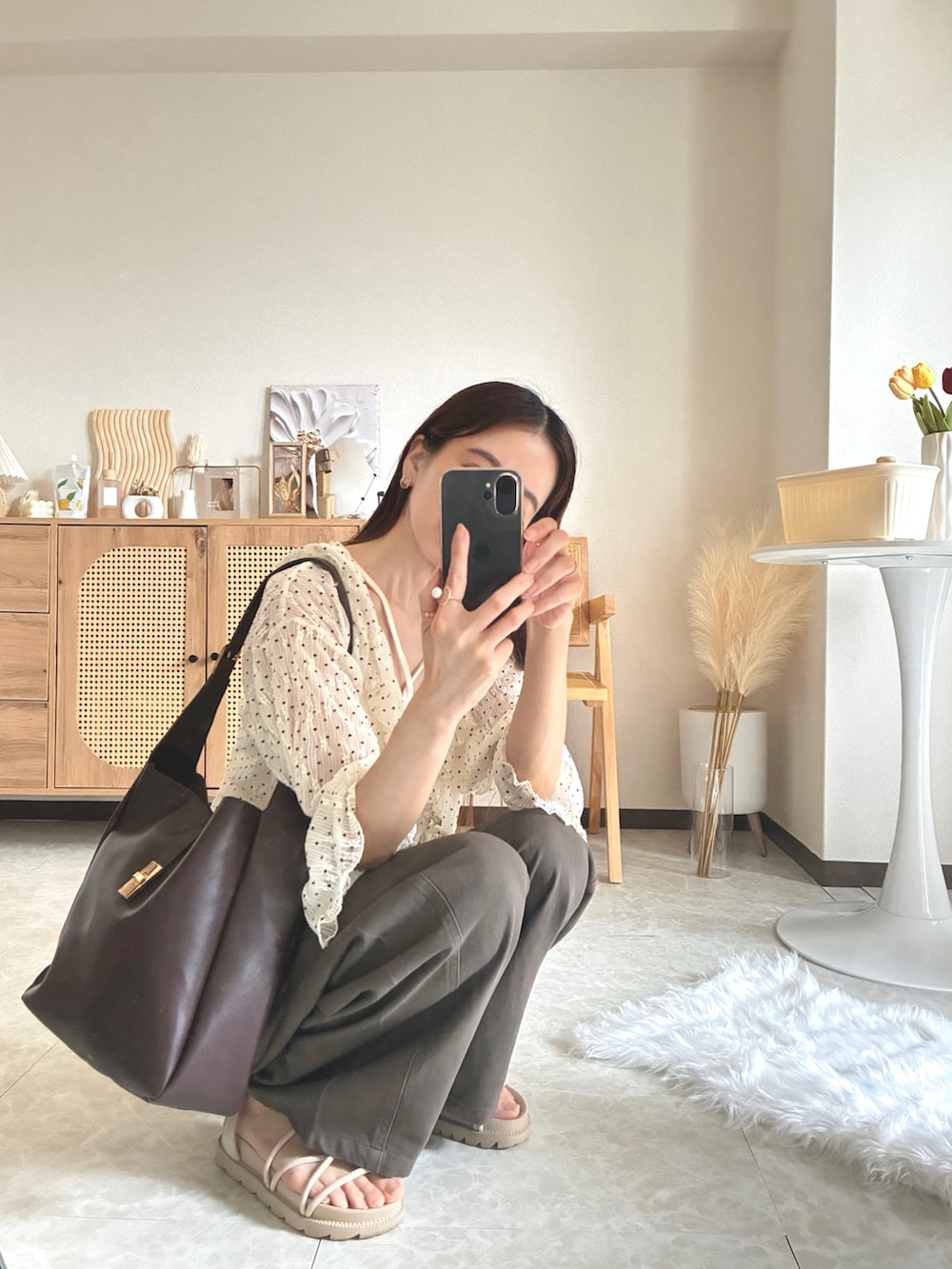 ホワイト系のカーディガン/ボレロ、ホワイト系のキャミソール、ブラウン系のデニムパンツを着用したレディースの夏コーディネートの5枚目の写真