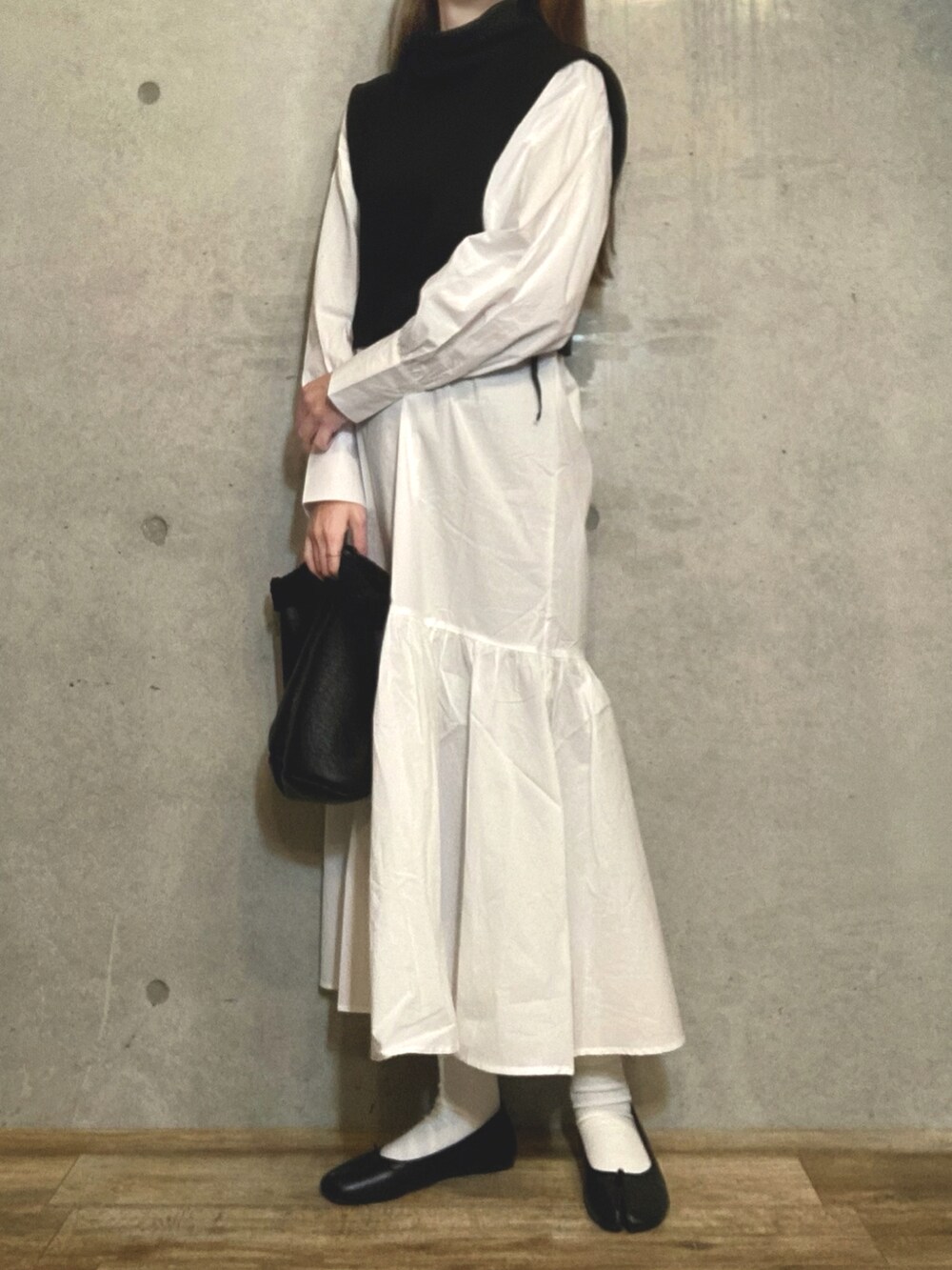ブラック系のトートバッグ、ブラック系のバレエシューズ、ホワイト系のワンピースを着用したレディースの冬コーディネートの3枚目の写真