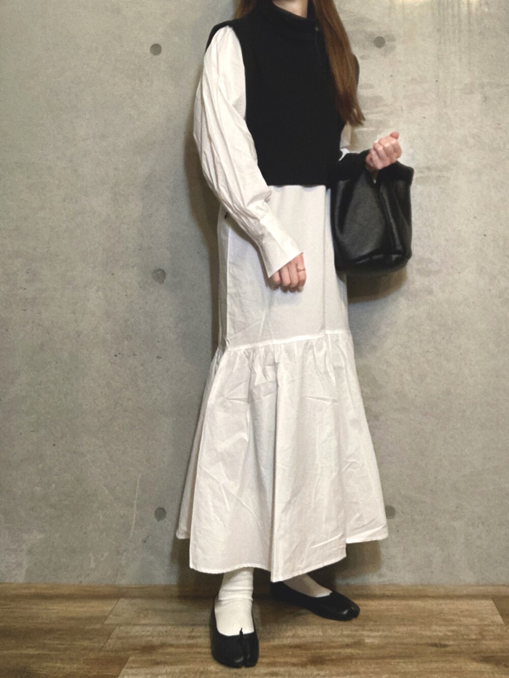 ブラック系のトートバッグ、ブラック系のバレエシューズ、ホワイト系のワンピースを着用したレディースの冬コーディネートの2枚目の写真