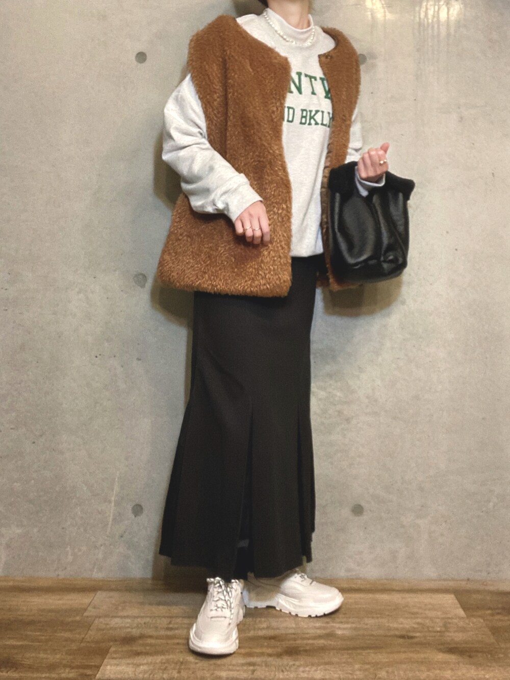 ブラック系のトートバッグ、ブラック系のスカート、ホワイト系のスニーカーを着用したレディースの冬コーディネートの2枚目の写真