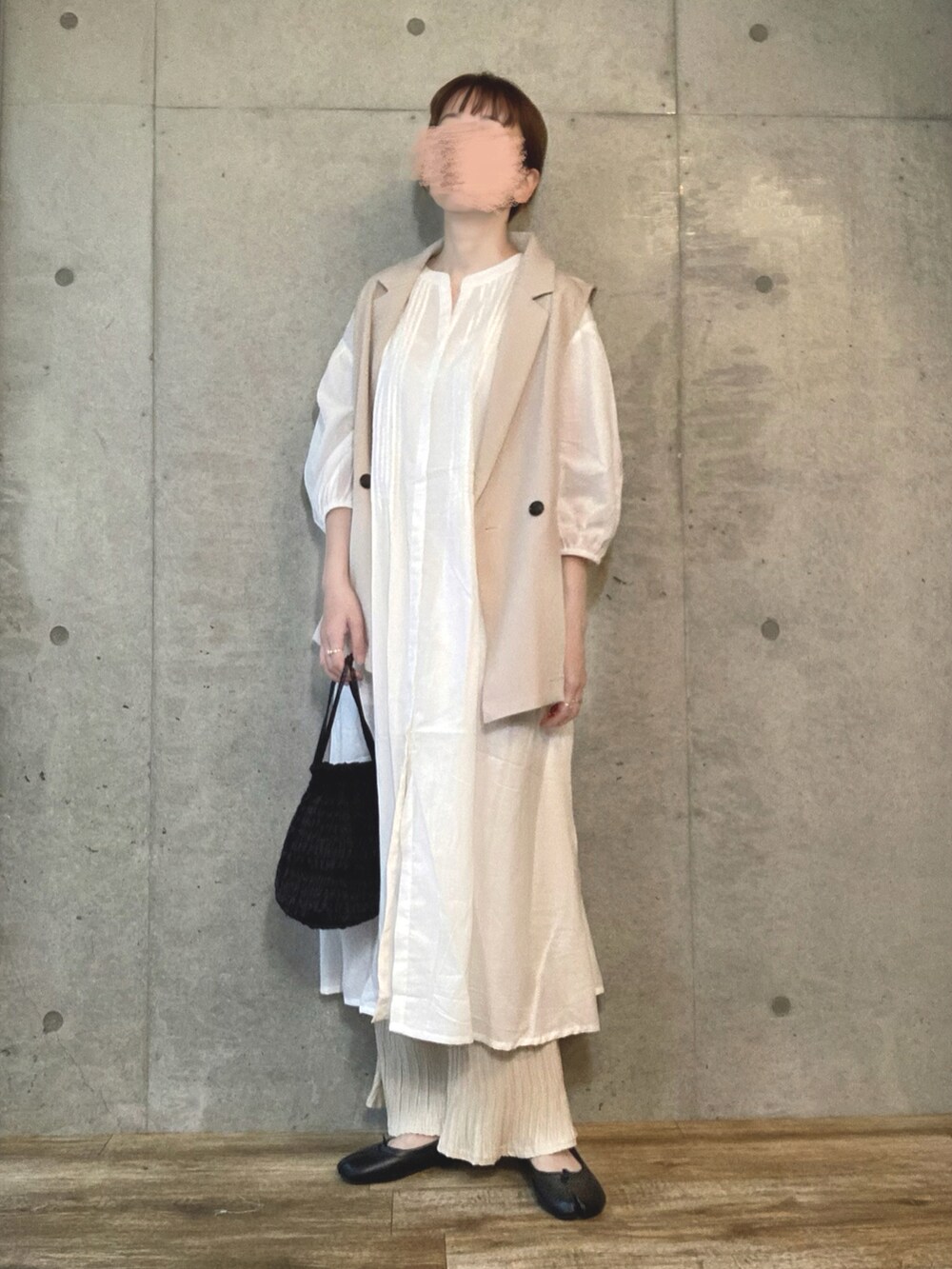 ホワイト系のベスト、ホワイト系のシャツワンピース、ブラック系のショルダーバッグを着用したレディースの夏コーディネートの3枚目の写真