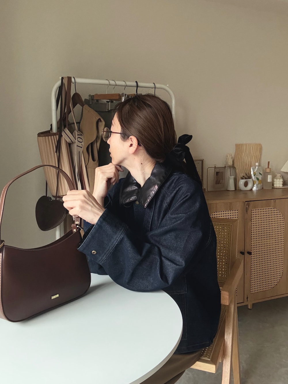 ブラウン系のハンドバッグ、ブルー系のカバーオール、イエロー系のその他パンツを着用したレディースの春コーディネートの4枚目の写真