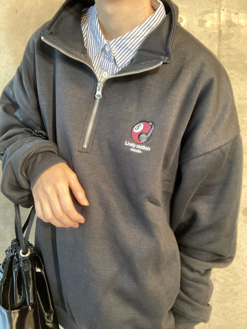 グレー系のスウェット、ブルー系のシャツ/ブラウス、ブラック系のハンドバッグを着用したレディースの秋コーディネートの3枚目の写真