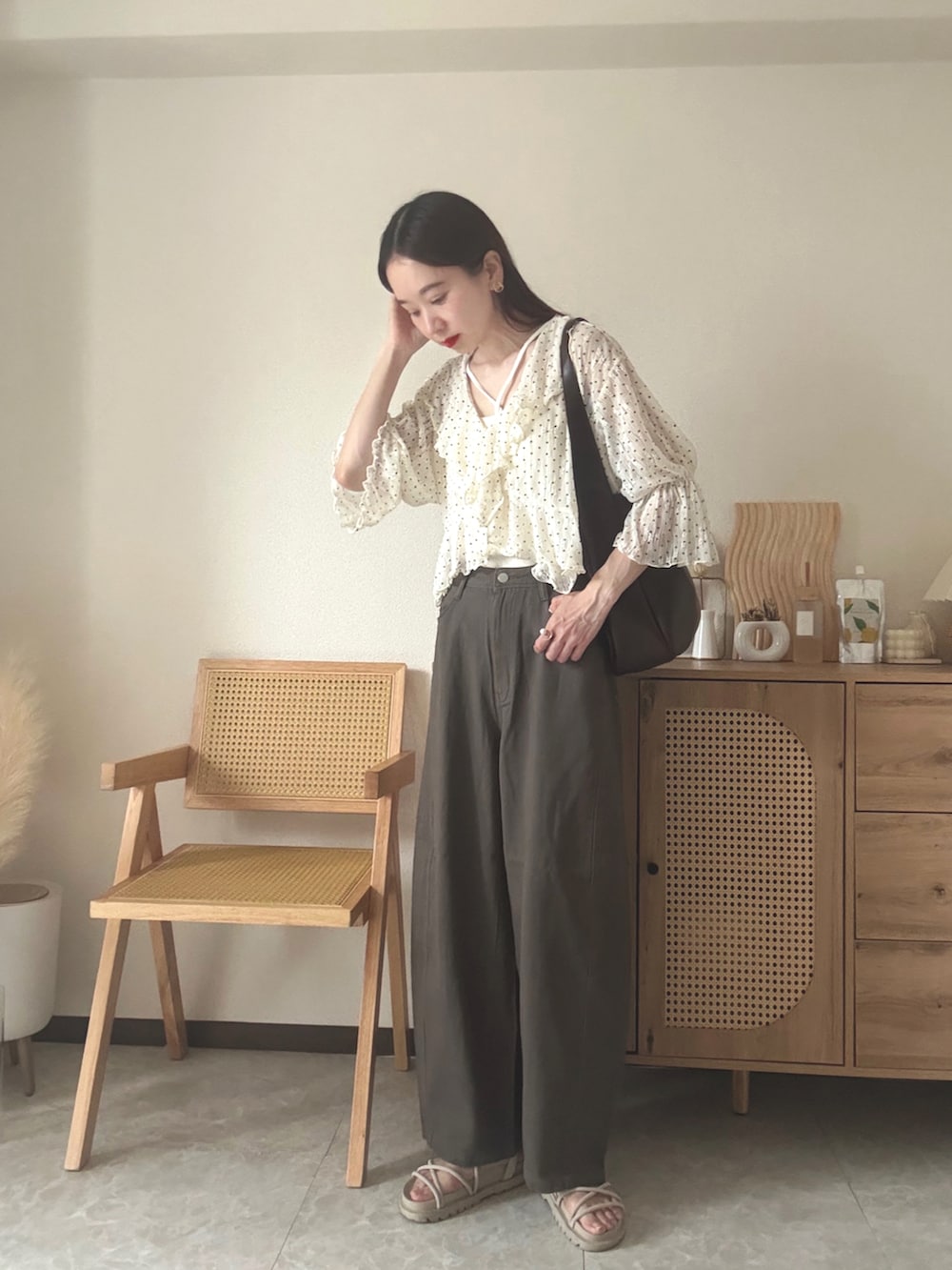 ホワイト系のカーディガン/ボレロ、ホワイト系のキャミソール、ブラウン系のデニムパンツを着用したレディースの夏コーディネートの3枚目の写真