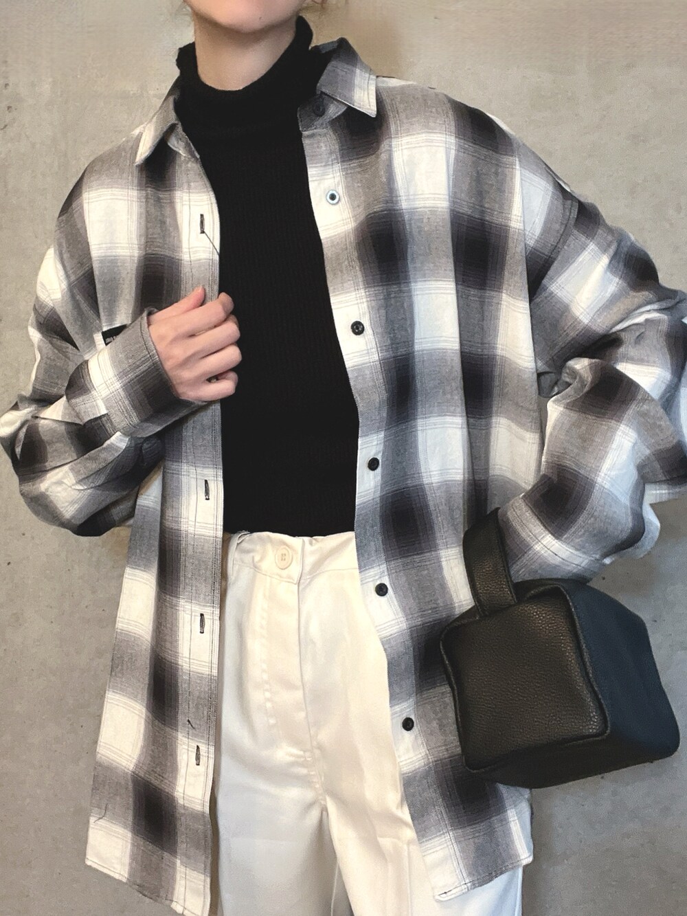 ホワイト系のシャツ/ブラウス、ホワイト系のスラックス、ブラック系のショルダーバッグを着用したレディースの冬コーディネートの4枚目の写真