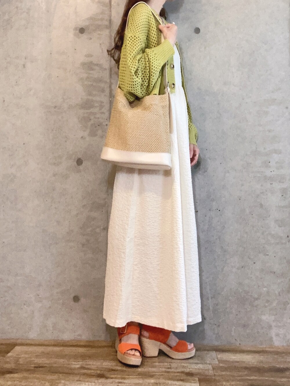 グリーン系のカーディガン/ボレロ、ホワイト系のワンピース、オレンジ系のサンダルを着用したレディースの夏コーディネートの2枚目の写真