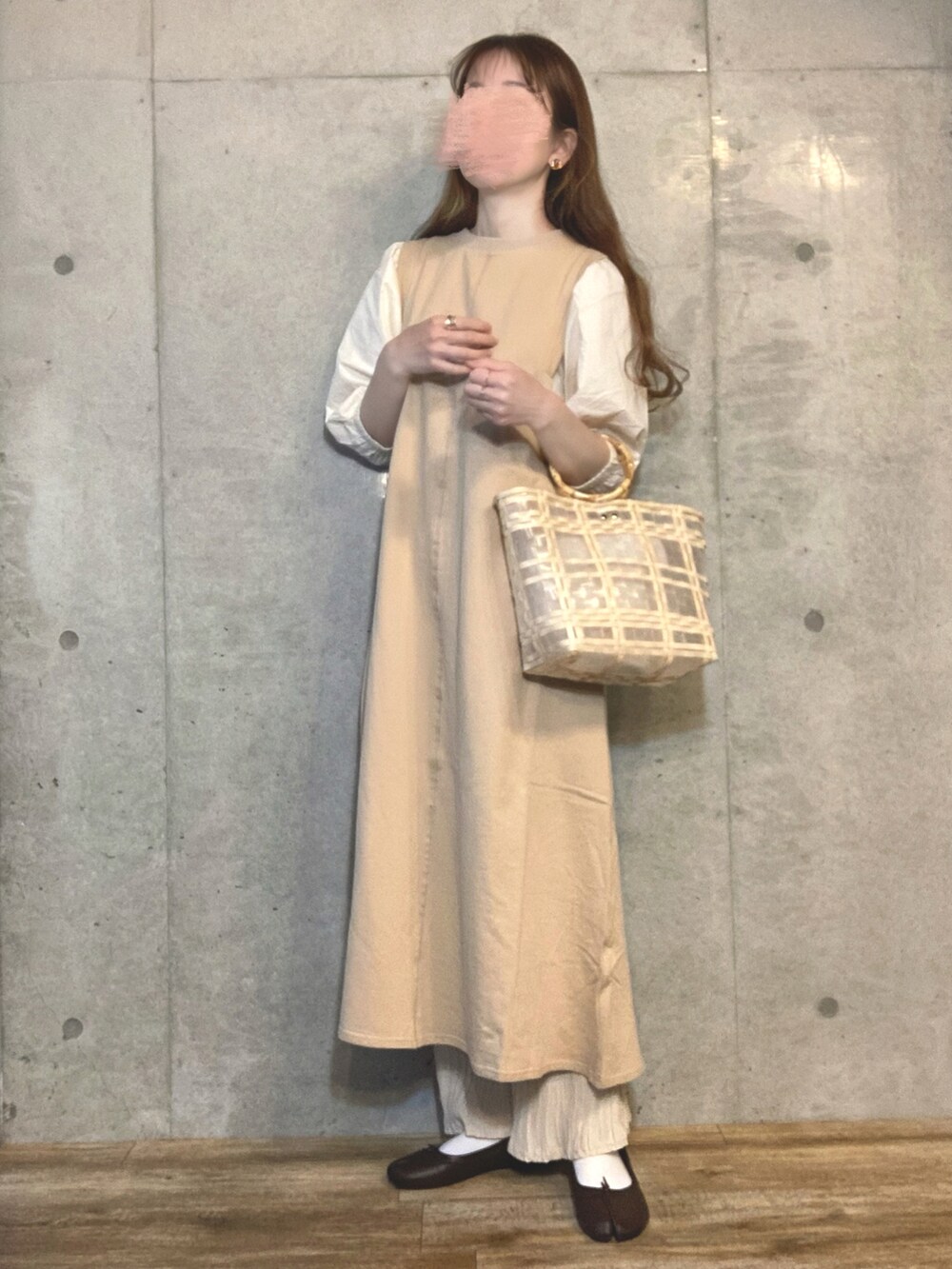 ベージュ系のワンピース、ベージュ系のハンドバッグ、ホワイト系のその他パンツを着用したレディースの春コーディネートの2枚目の写真