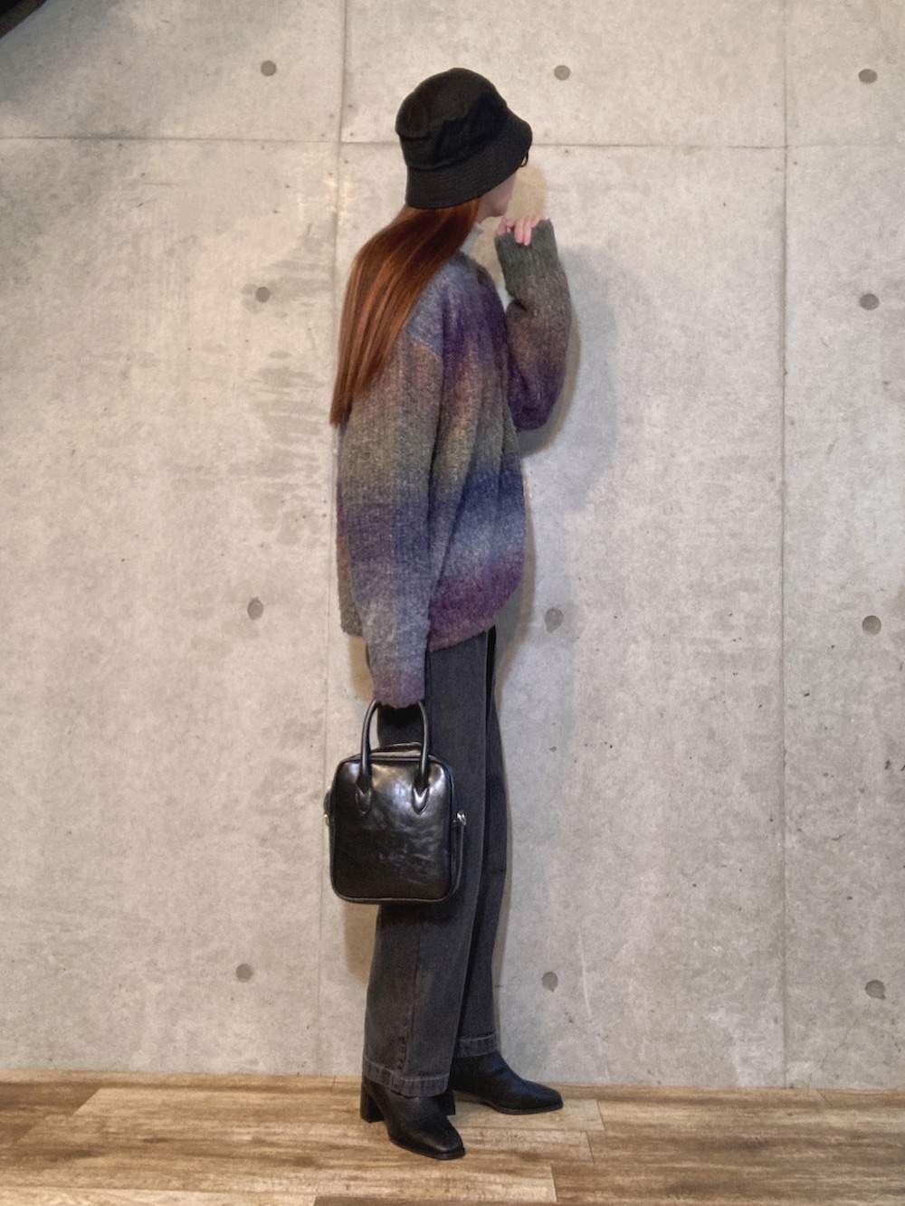 ホワイト系のニット/セーター、ブラック系のデニムパンツ、ブラック系のショルダーバッグを着用したレディースの冬コーディネートの2枚目の写真