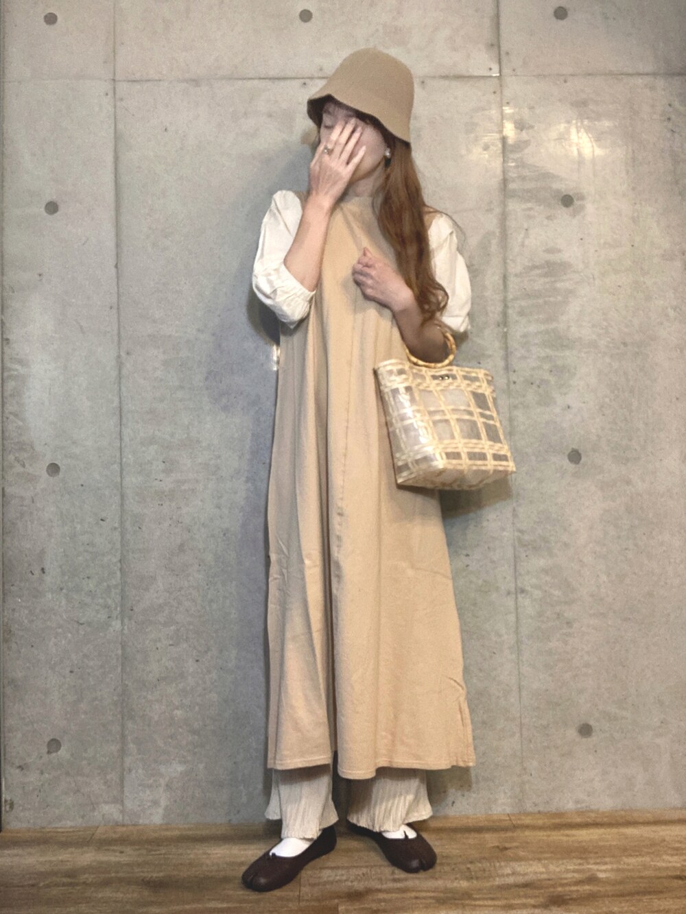 ベージュ系のワンピース、ベージュ系のハンドバッグ、ホワイト系のその他パンツを着用したレディースの春コーディネートの3枚目の写真