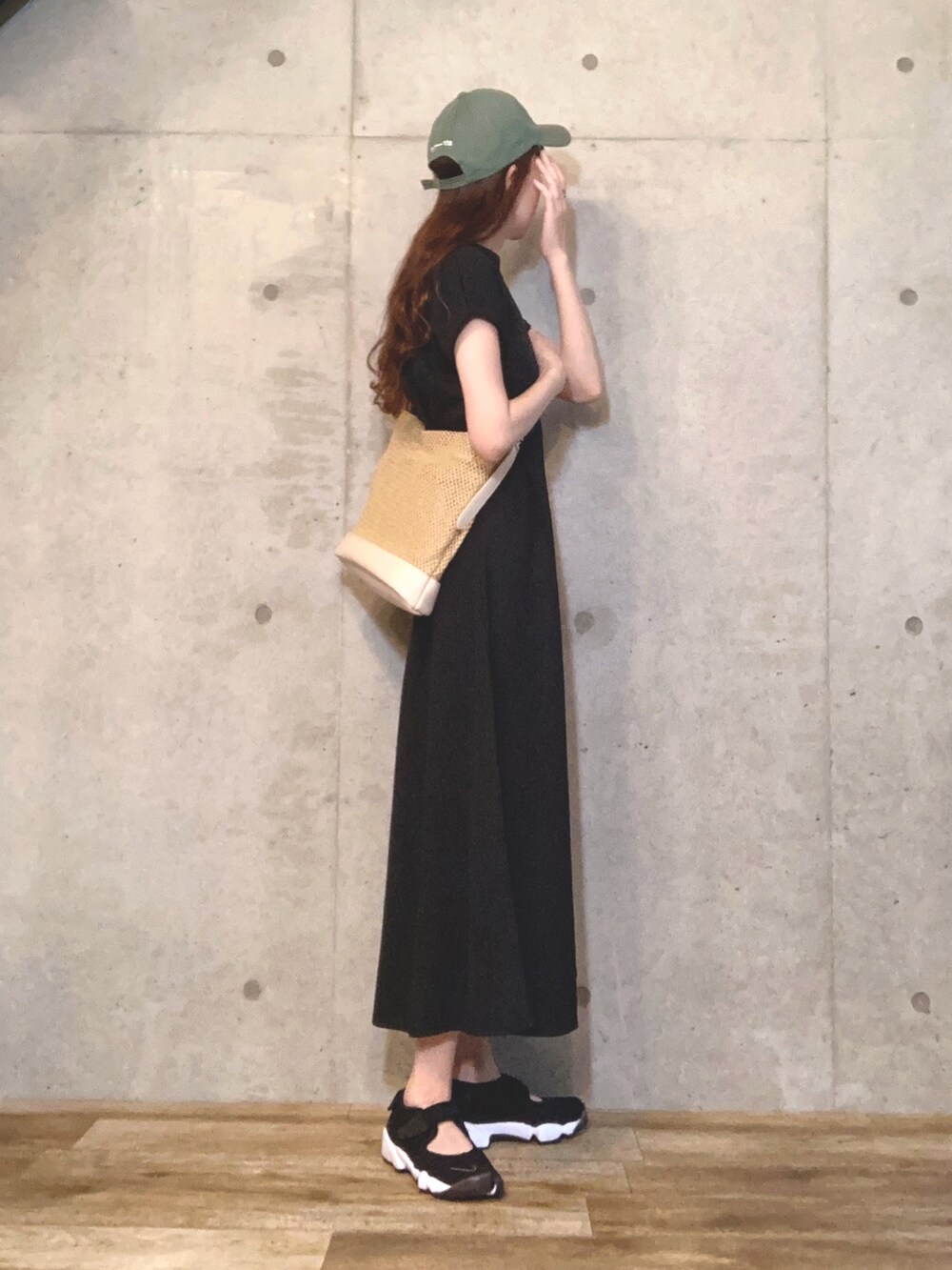 ブラック系のワンピース、ホワイト系のハンドバッグ、ホワイト系のカーディガン/ボレロを着用したレディースの夏コーディネートの2枚目の写真