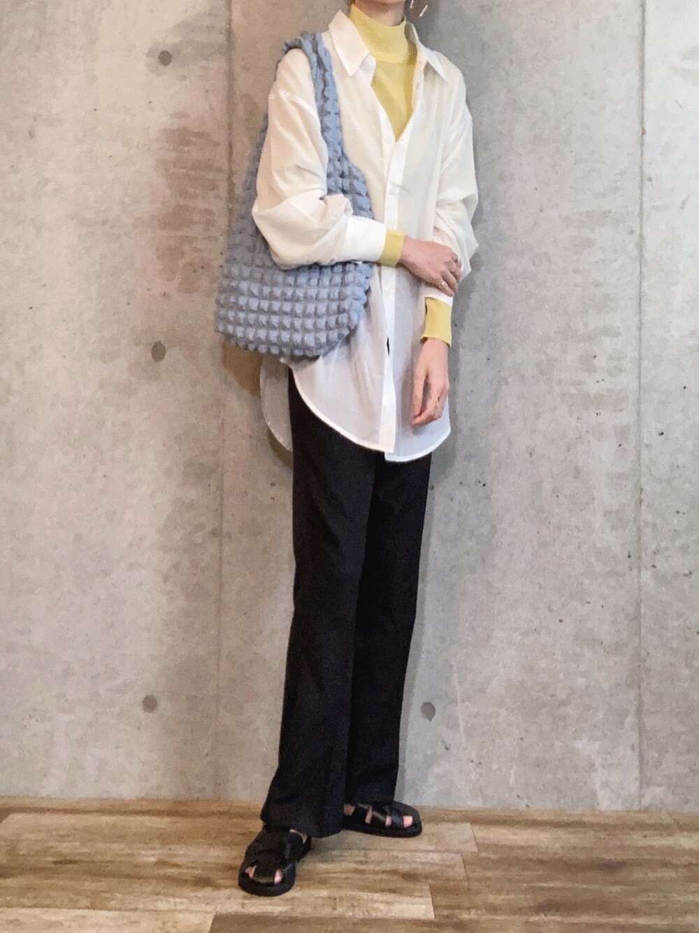 ホワイト系のシャツ/ブラウス、イエロー系のニット/セーター、ブラック系のその他パンツを着用したレディースの春コーディネートの2枚目の写真