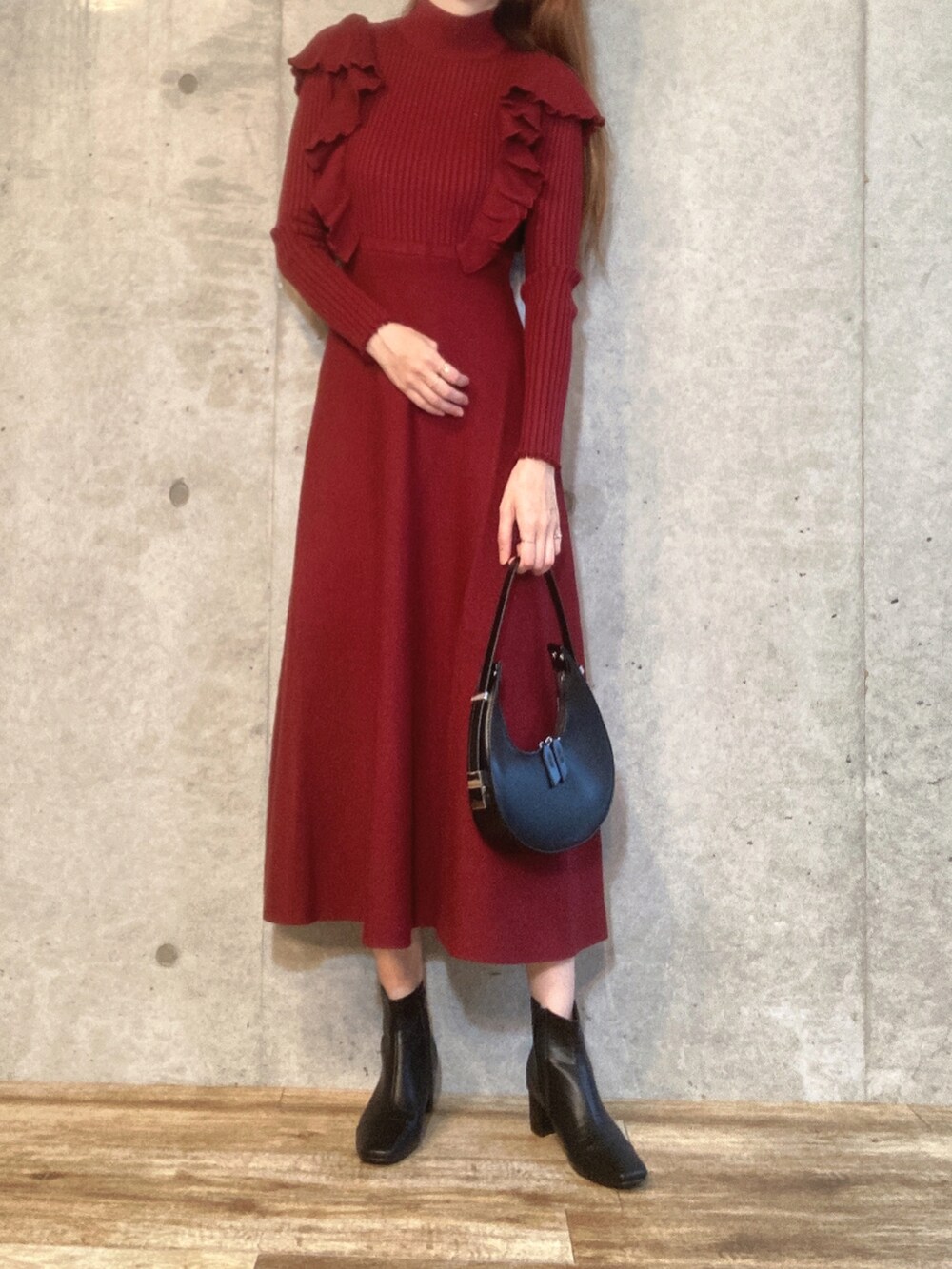 ブラウン系のワンピース、ブラック系のハンドバッグ、ブラック系のブーツを着用したレディースの秋コーディネートの2枚目の写真