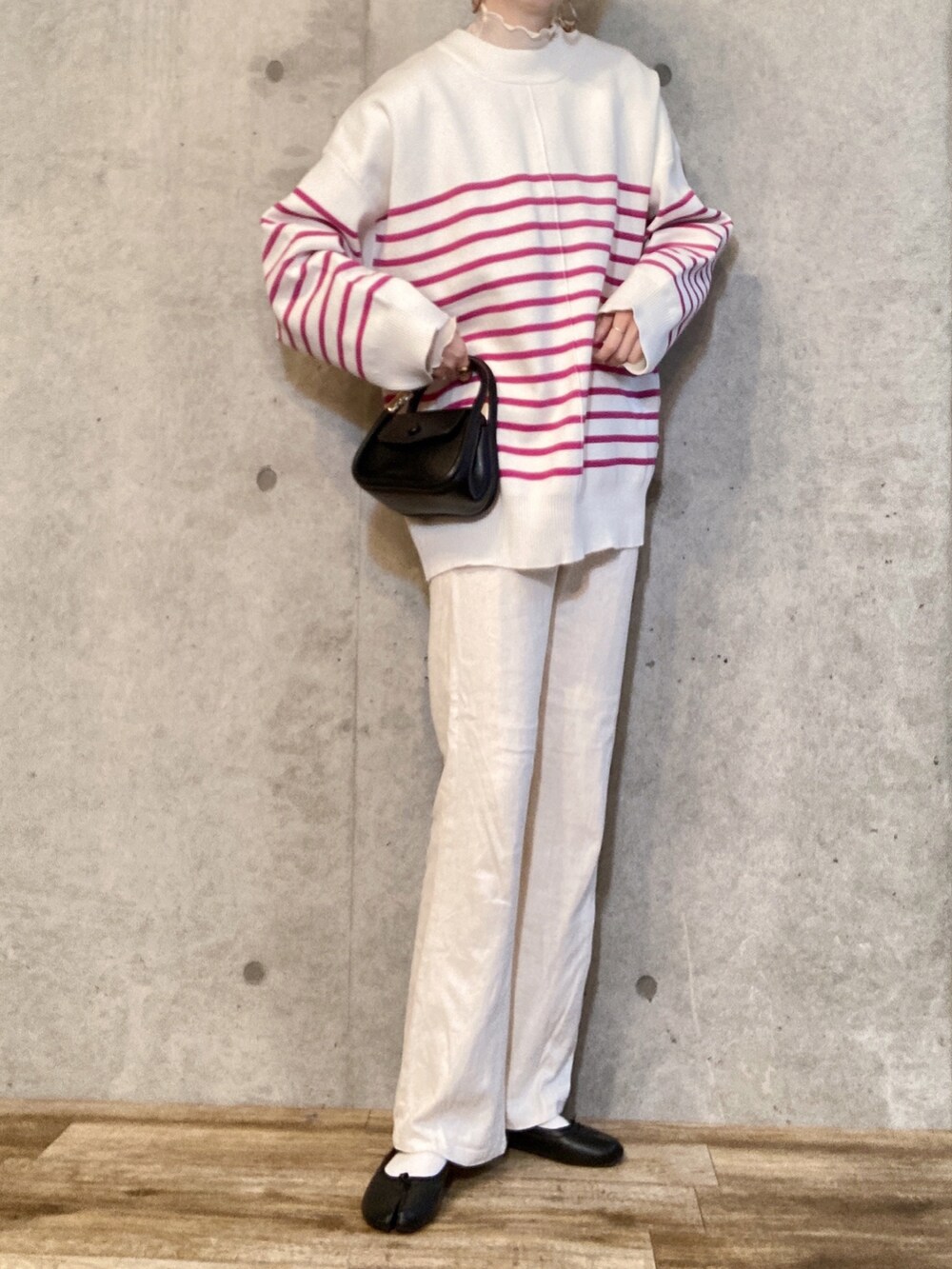 ピンク系のカーディガン/ボレロ、ブラック系のバレエシューズ、ブラック系のショルダーバッグを着用したレディースの冬コーディネートの2枚目の写真