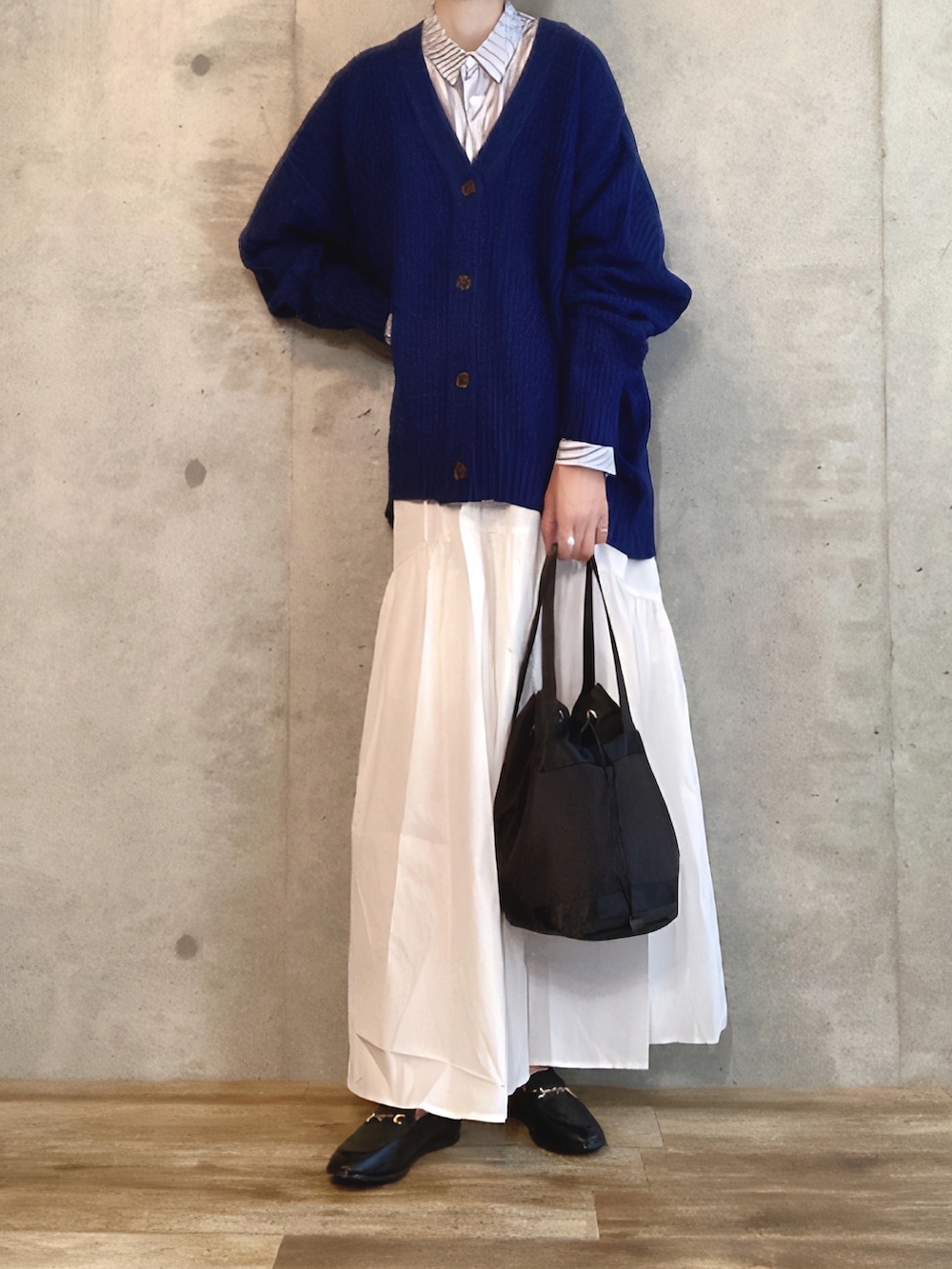 ブルー系のカーディガン/ボレロ、ブルー系のシャツ/ブラウス、ホワイト系のスカートを着用したレディースの秋コーディネートの2枚目の写真