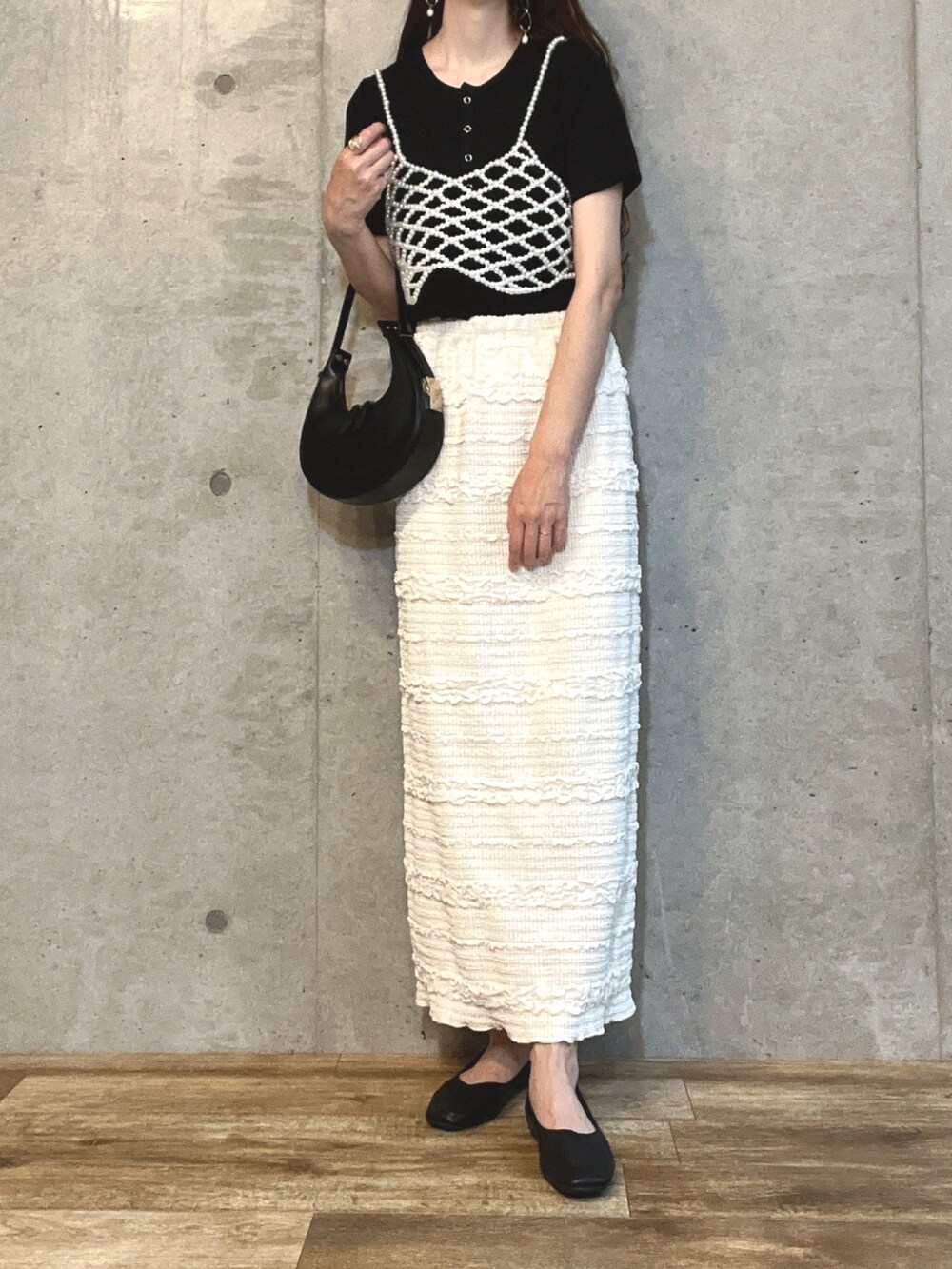 ブラック系のTシャツ/カットソー、ホワイト系のベスト、ホワイト系のスカートを着用したレディースの夏コーディネートの2枚目の写真