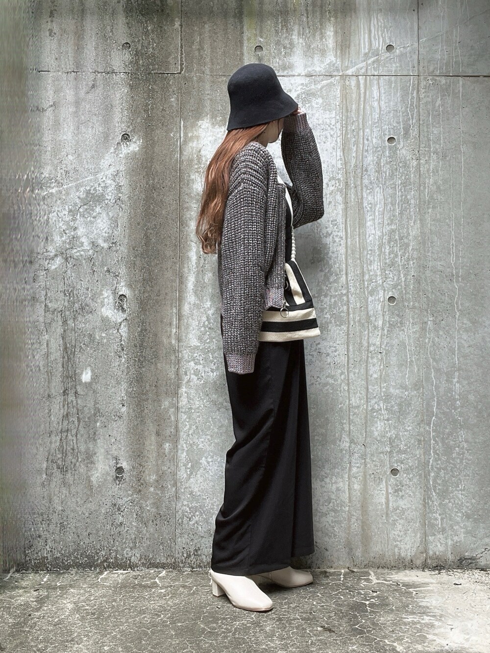 グレー系のニット/セーター、ホワイト系のTシャツ/カットソー、ホワイト系のショルダーバッグを着用したレディースの秋コーディネートの3枚目の写真