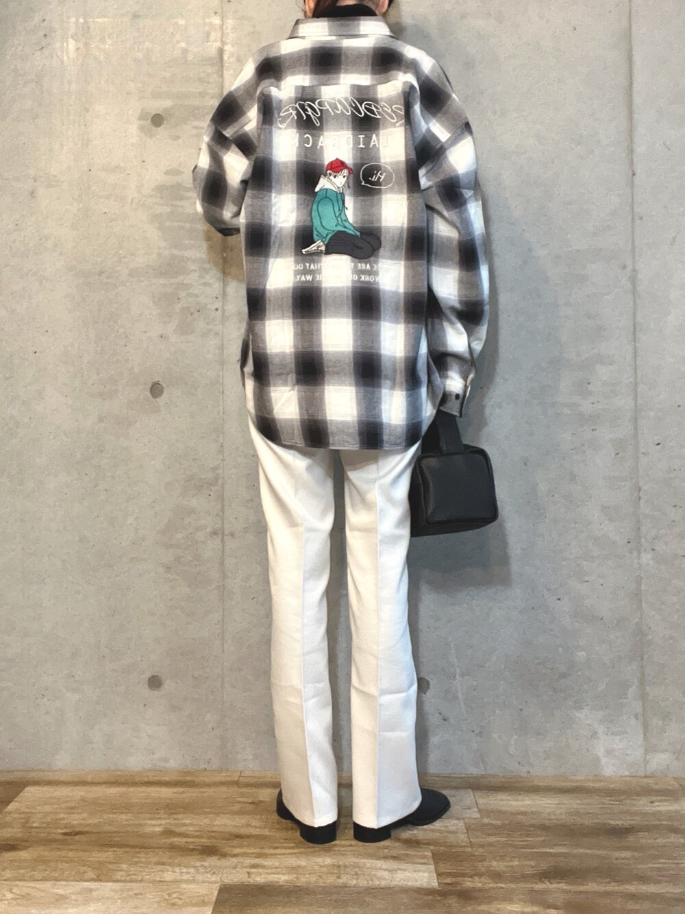 ホワイト系のシャツ/ブラウス、ホワイト系のスラックス、ブラック系のショルダーバッグを着用したレディースの冬コーディネートの2枚目の写真