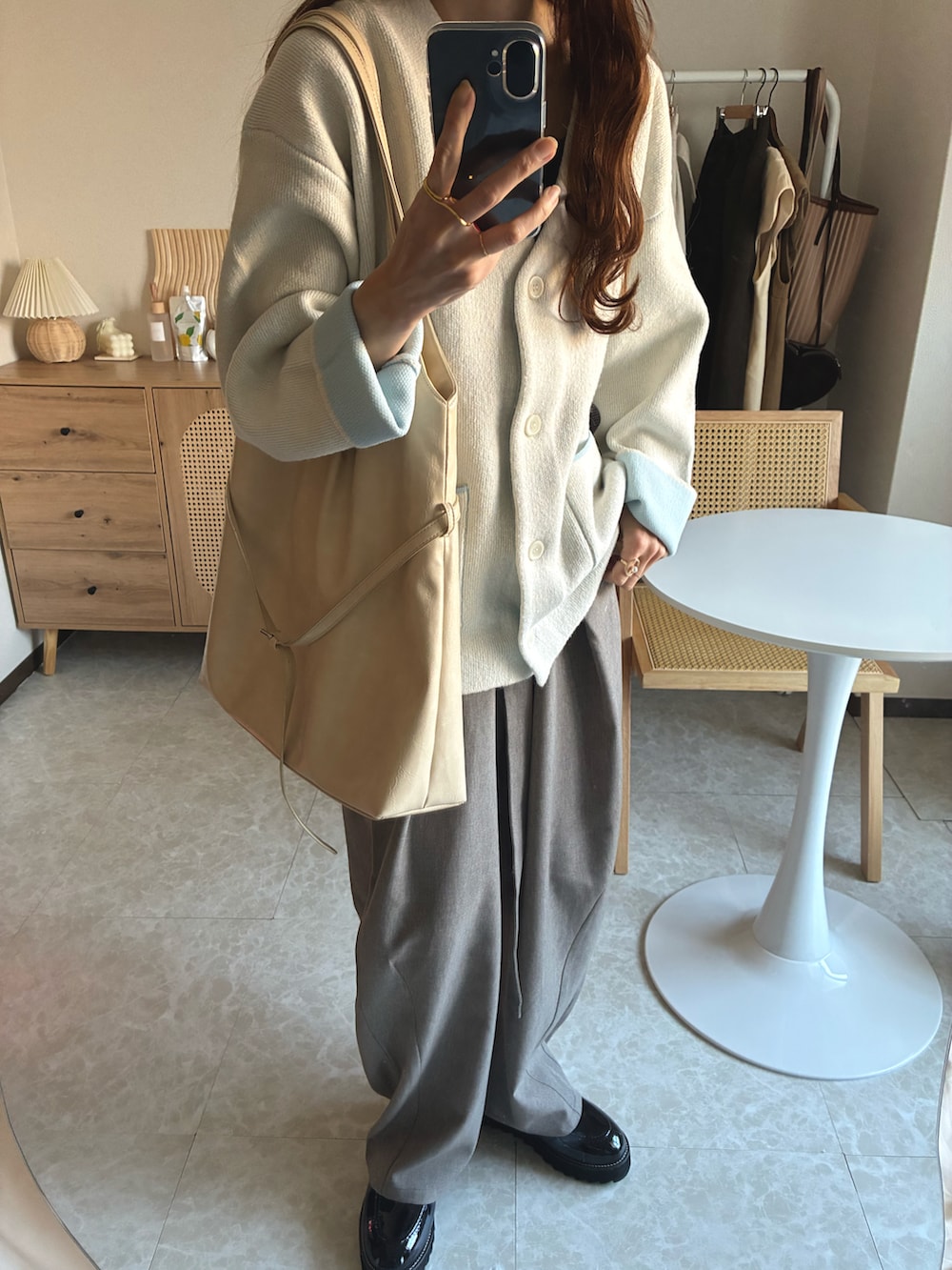 ホワイト系のカーディガン/ボレロ、ベージュ系のその他パンツ、ホワイト系のトートバッグを着用したレディースの冬コーディネートの2枚目の写真