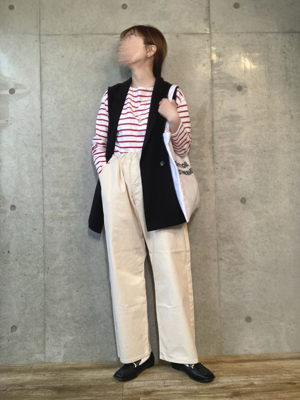 ブラック系のベスト、ホワイト系のトートバッグ、ホワイト系のその他パンツを着用したレディースの春コーディネートの2枚目の写真