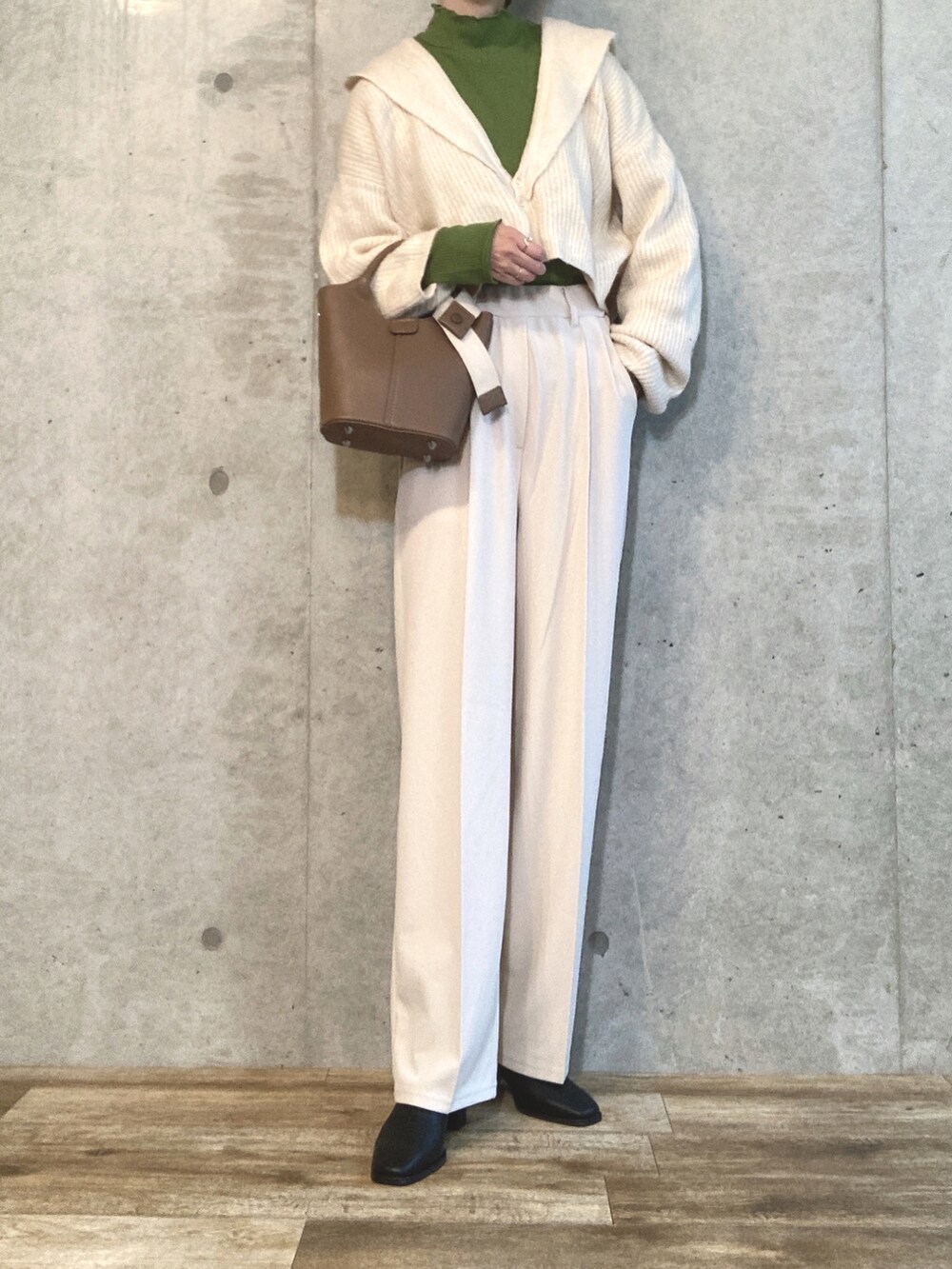 ホワイト系のカーディガン/ボレロ、グリーン系のTシャツ/カットソー、ブラウン系のハンドバッグを着用したレディースの秋コーディネートの3枚目の写真