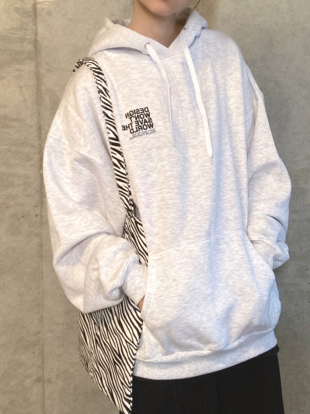 グレー系のパーカー、その他のトートバッグ、ブラック系のスカートを着用したレディースの秋コーディネートの3枚目の写真