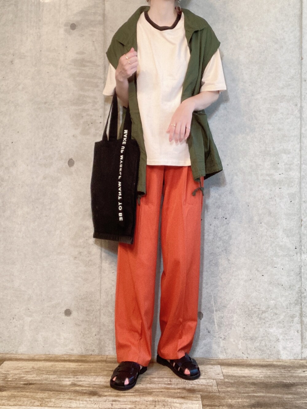 グリーン系のベスト、ベージュ系のTシャツ/カットソー、オレンジ系のスラックスを着用したレディースの夏コーディネートの2枚目の写真