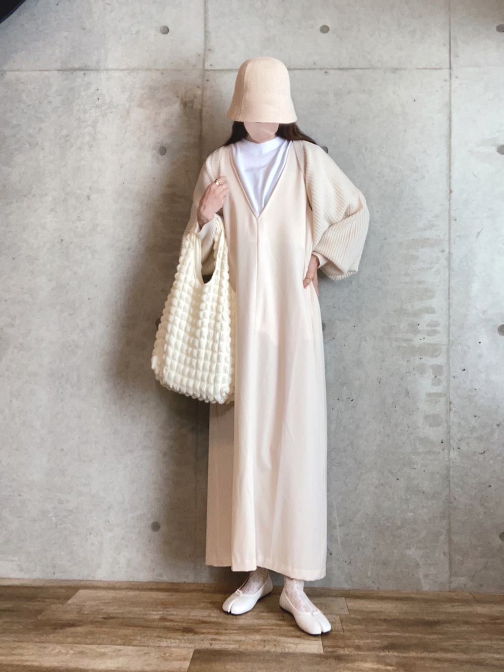 ホワイト系のカーディガン/ボレロ、ホワイト系のジャンパースカート、ホワイト系のバレエシューズを着用したレディースの春コーディネートの2枚目の写真